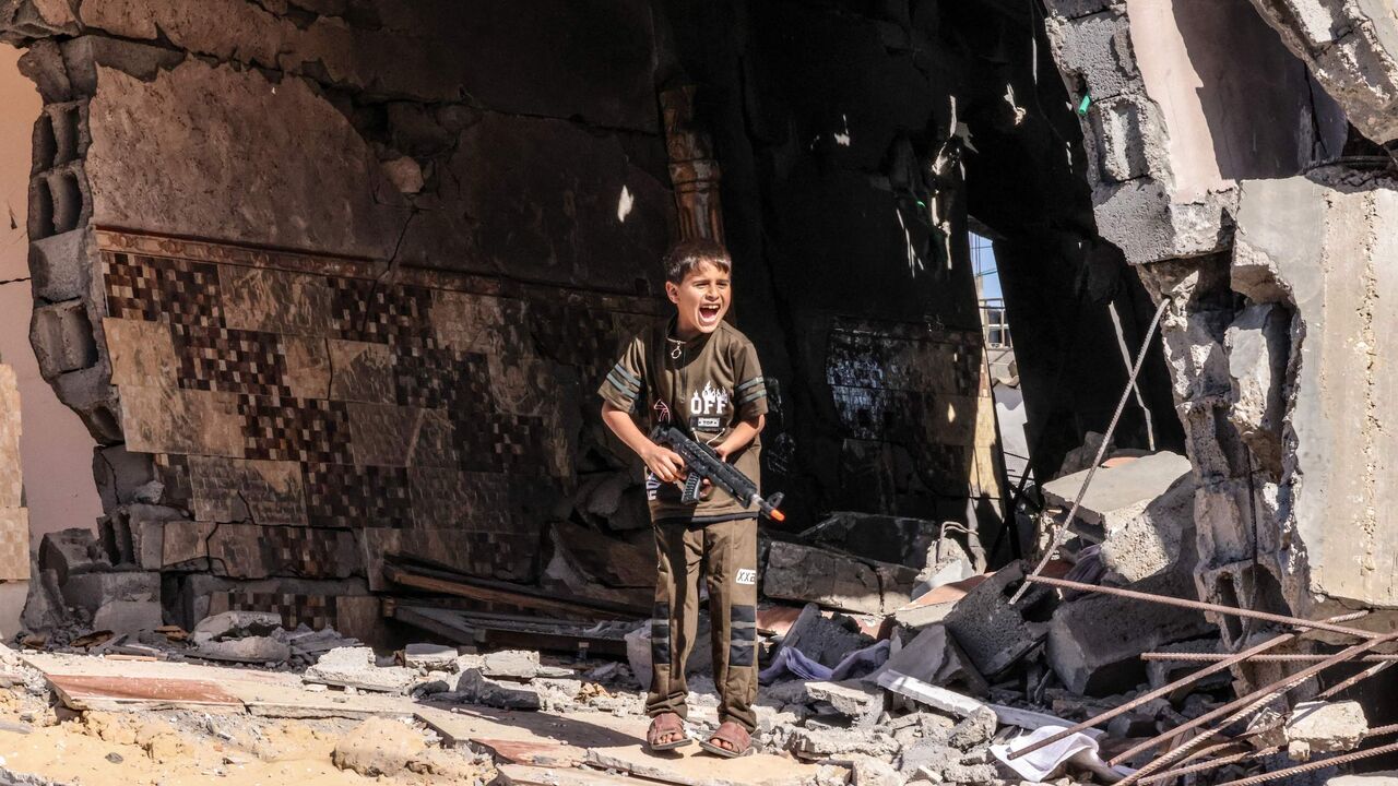 A Palestinian child plays with a toy gun.