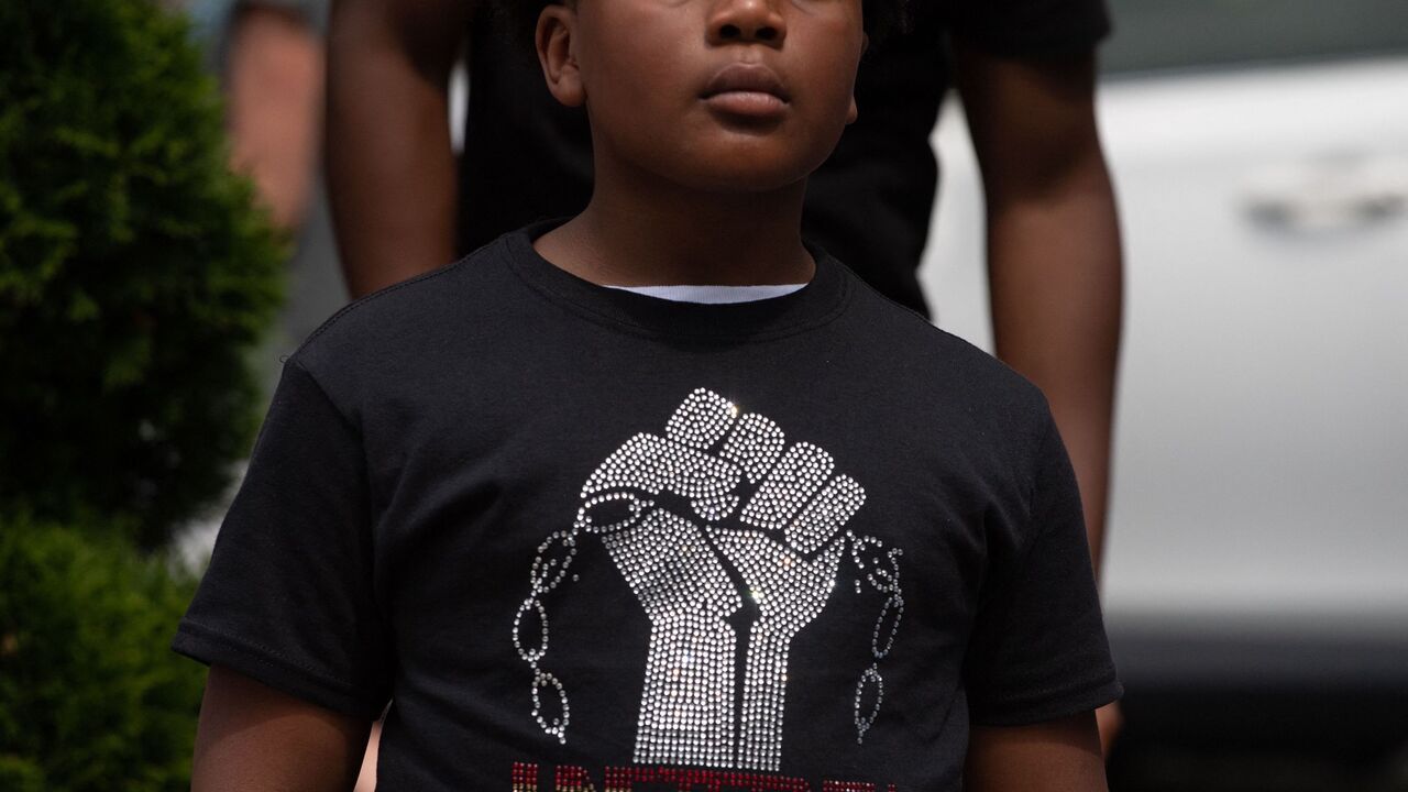 A boy listens to Live Go-Go music playing at Black Lives Matter Plaza in Washington, DC, on June 19, 2021.