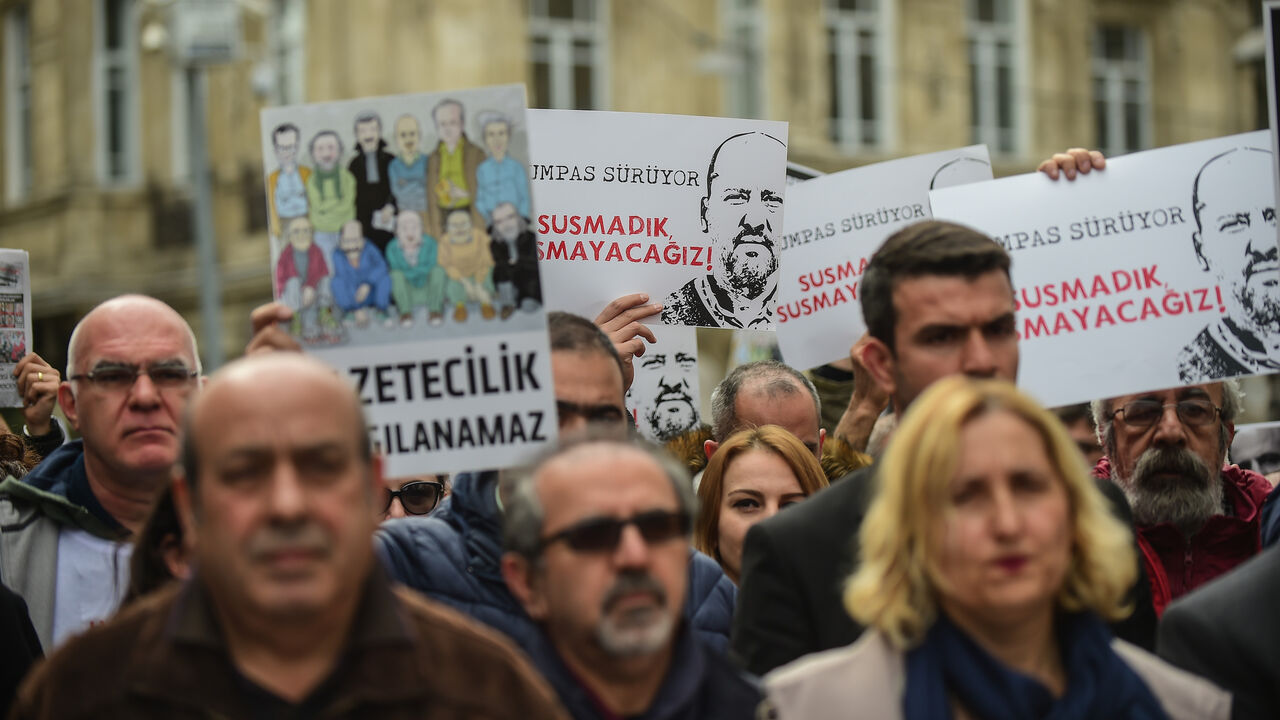 People and journalists hold banners reading "Freedom for jailed journalists - we will not be silenced" on April 9, 2017 during a demonstration for the freedom of the press in Istanbul. 