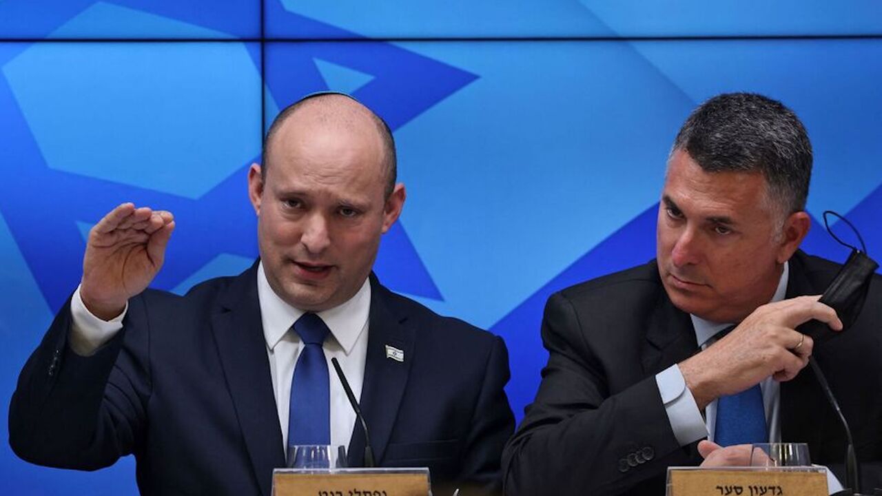 Israeli Prime Minister Naftali Bennett speaks during a press conference on the economy in Jerusalem, on July 6, 2021, flanked by Justice Minister Gideon Saar. 