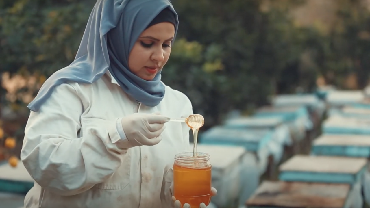 Samar al-Baa inspects honey collected from her beehives in Beit Hanoun, Gaza Strip, in a still from a video uploaded May 30, 2021.