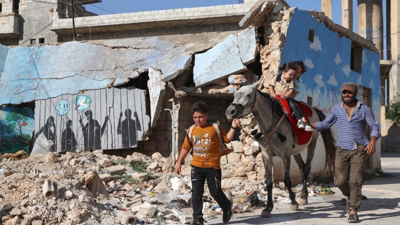 Children take a donkey ride during Eid al-Adha celebrations in Syria's rebel-held Idlib province on July 9, an area reliant on UN aid brought across the border from Turkey