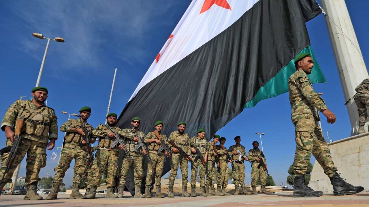 Turkey-backed Syrian fighters take part in a parade in the rebel-controlled town of Tell Abyad in Raqqa province, Syria, Oct. 13, 2020.