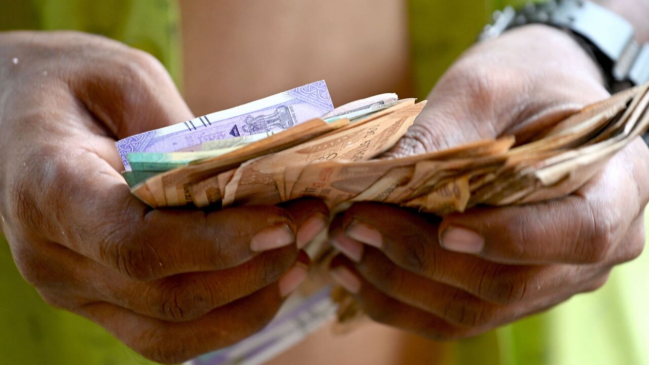 A man counts Indian rupee notes in Mumbai on May 9, 2022.