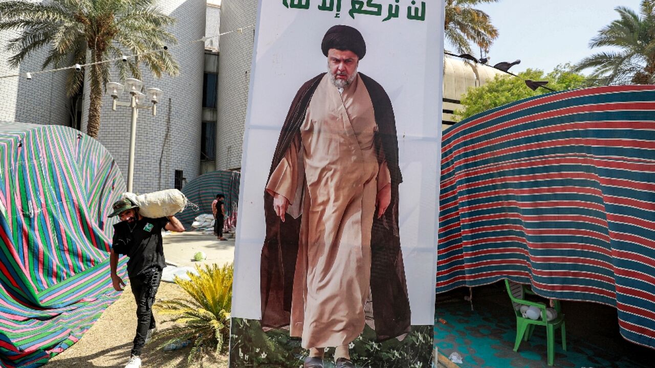 A Sadr supporter carries away items as they leave Baghdad's Green Zone