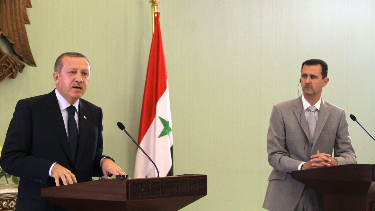 Syrian President Bashar al-Assad (R) listens on as Turkish Prime Minister Recep Tayyip Erdogan speaks during a joint press conference at al-Shaab palace in Damascus on Oct. 11, 2010. 