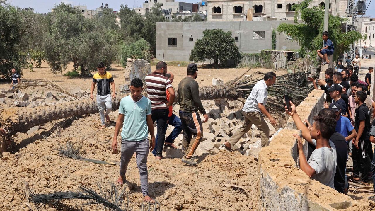 People inspect a destroyed house following an Israeli air strike, in Khan Yunis in the southern Gaza Strip on August 6, 2022.  