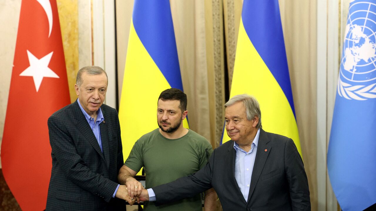 Turkish President Recep Tayyip Erdogan, Ukrainian President Volodymyr Zelensky and UN Secretary-General Antonio Guterres shake hands.