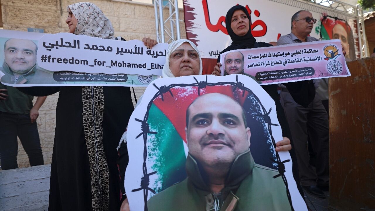 Mohammed Halabi, former Gaza director of World Vision, was sentenced to 12 years in jail on Tuesday for sending cash to Hamas: in this June 2022 photograph his mother holds his portrait in a rally demanding his release Mohammed Halabi, former Gaza director of World Vision, was sentenced to 12 years in jail on Tuesday for sending cash to Hamas: in this June 2022 photograph his mother holds his portrait in a rally demanding his release