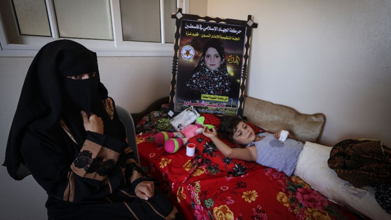 Palestinian mother Rasha Qadoom mourns her five year-old daughter Alaa, who was killed in an Israeli bombardment of Gaza, as she looks after her surviving child Rayed, who was wounded