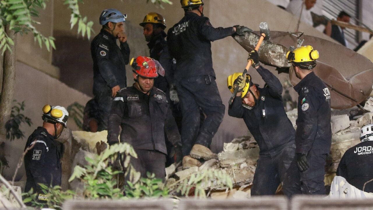 Rescue workers search for people buried under the rubble of a collapsed building in Amman, Jordan Rescue workers search for people buried under the rubble of a collapsed building in Amman, Jordan