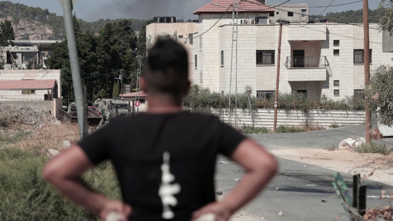 A Palestinian youth holds stones in readiness to hurl at Israeli soldiers  carrying out a raid in Jenin in which four people were killed