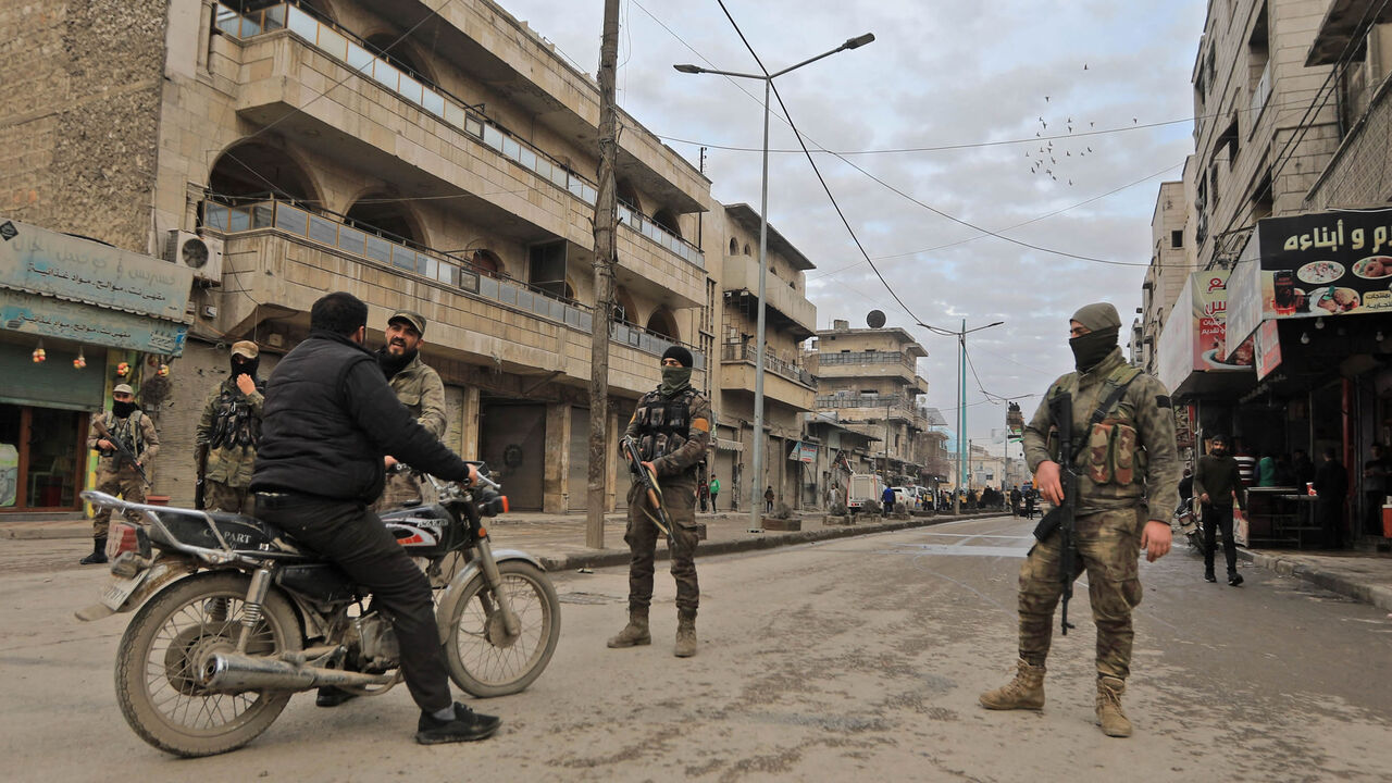 Turkey-backed Syrian rebel fighters man a roadblock in the Turkish-controlled city of al-Bab following reported artillery shelling, northern Aleppo province, Syria, Feb. 2, 2022.