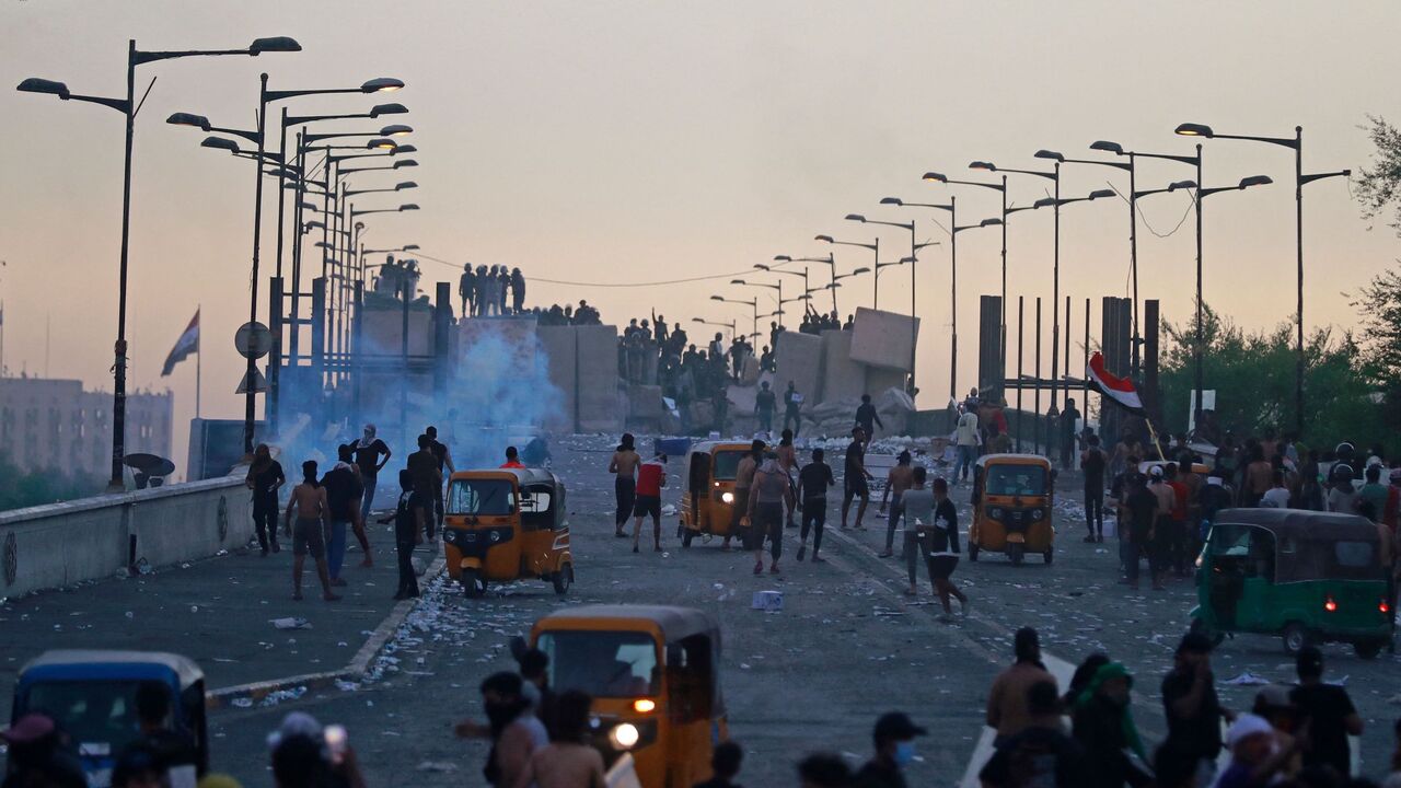 Supporters of Shiite Muslim cleric Muqtada al-Sadr clash with Iraqi security forces in Liberation Square in the centre of Iraq's capital Baghdad on Sept. 28, 2022, during a parliament session in the nearby high-security Green Zone across the Tigris river. 