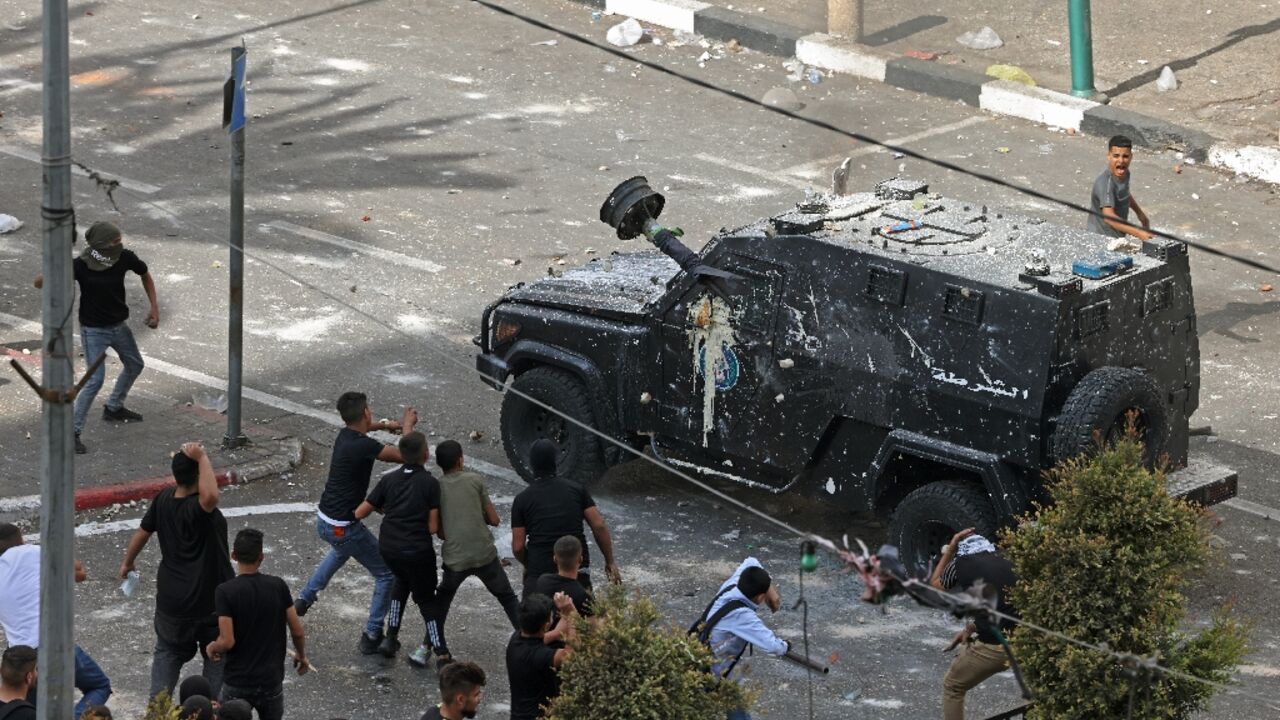 Protesters hurl stones at Palestinian security forces as they carry out an arrest operation in the main northern West Bank city of Nablus