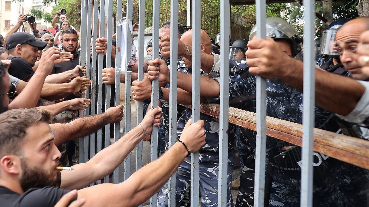 Protesters at the gates of the Justice Palace in Lebanon's capital Beirut on September 19, 202, demand the release of two people involved in a bank hold-up last week