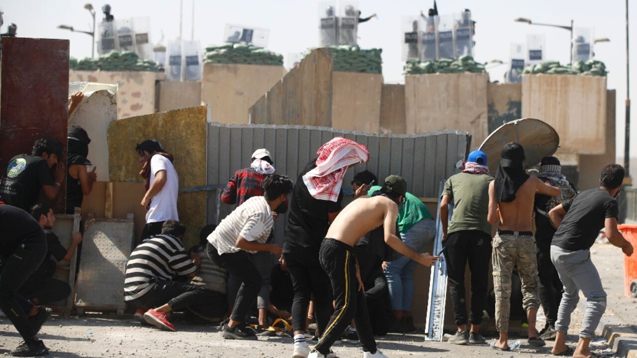Iraqi anti-government demonstrators clash with security forces during a protest on the Jumhuriya (Republic) bridge leading to the capital Baghdad's high-security Green Zone on October 1, 2022 Iraqi anti-government demonstrators clash with security forces during a protest on the Jumhuriya (Republic) bridge leading to the capital Baghdad's high-security Green Zone on October 1, 2022