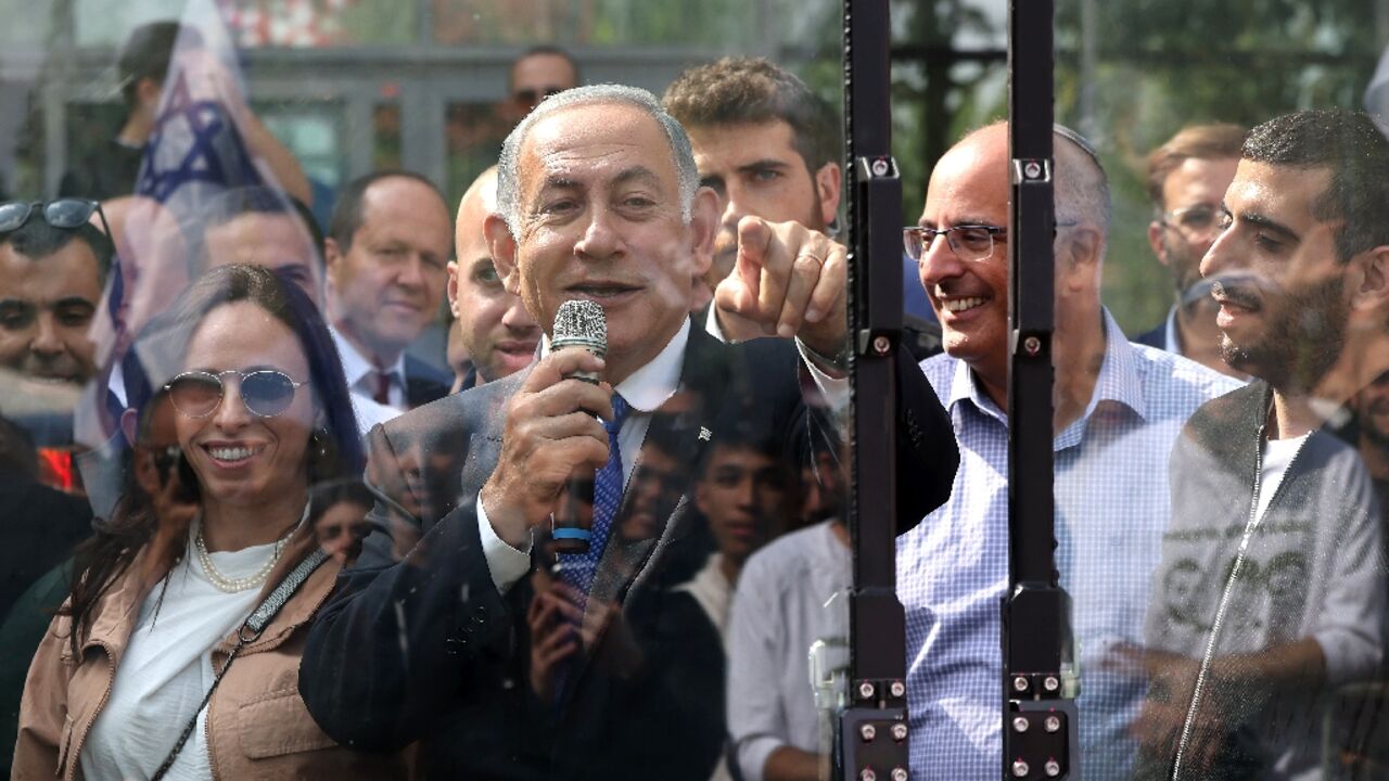 Israel's former prime minister and leader of the Likud party Benjamin Netanyahu speaks from behind a security screen during a campaign rally in the West Bank settlement of Ariel on October 26, 2022 