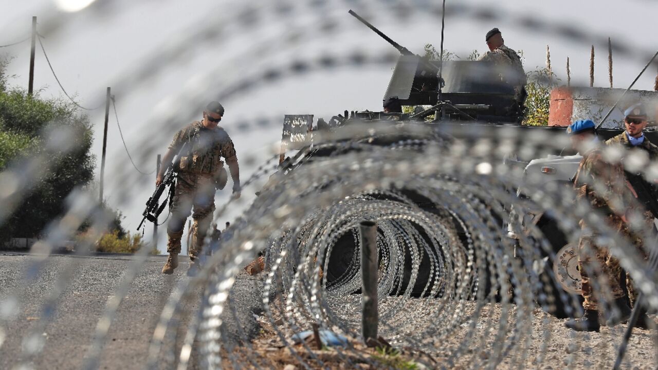 Lebanese army soldiers (L) stand by an infantry-fighting vehicle (IFV) near peacekeepers (R) of the United Nations Interim Force In Lebanon (UNIFIL) in Naqura along the border with northern Israel on Thursday Lebanese army soldiers (L) stand by an infantry-fighting vehicle (IFV) near peacekeepers (R) of the United Nations Interim Force In Lebanon (UNIFIL) in Naqura along the border with northern Israel on Thursday