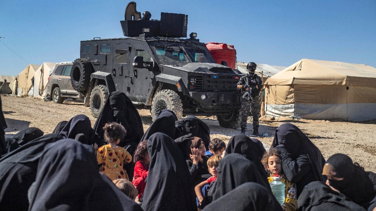 A member of the Syrian Kurdish security forces stands guard during an inspection at the Al-Hol camp, which holds relatives of suspected Islamic State (IS) group fighters, pictured here in August