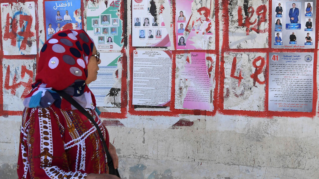 A Tunisian woman looks at posters of candidates for the legislative elections, Tunis, Tunisia, Oct. 4, 2019.