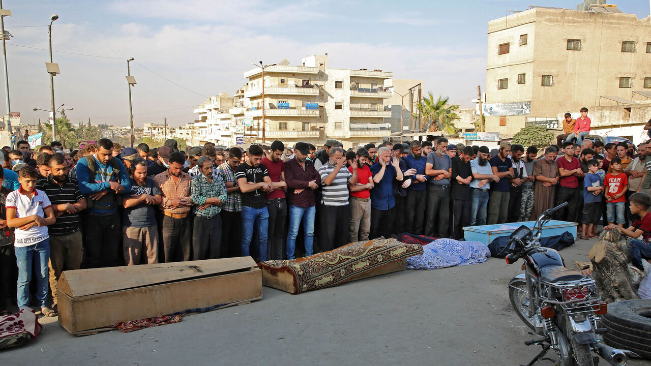 Syrians take part in the funeral of 10 fighters with the Turkey-backed Faylaq al-Sham rebel faction in Syria, in the northwestern city of Idlib, following their death in a Russian airstrike, Syria, Oct. 26, 2020.