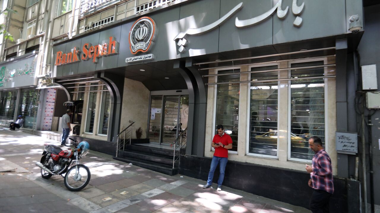 Iranians walk past Sepah Bank in the capital Tehran, on June 15, 2022. - Iran has been wrestling with rampant price growth for years, exceeding 30 percent annually every year since 2018, according to the International Monetary Fund. (Photo by ATTA KENARE / AFP) (Photo by ATTA KENARE/AFP via Getty Images)