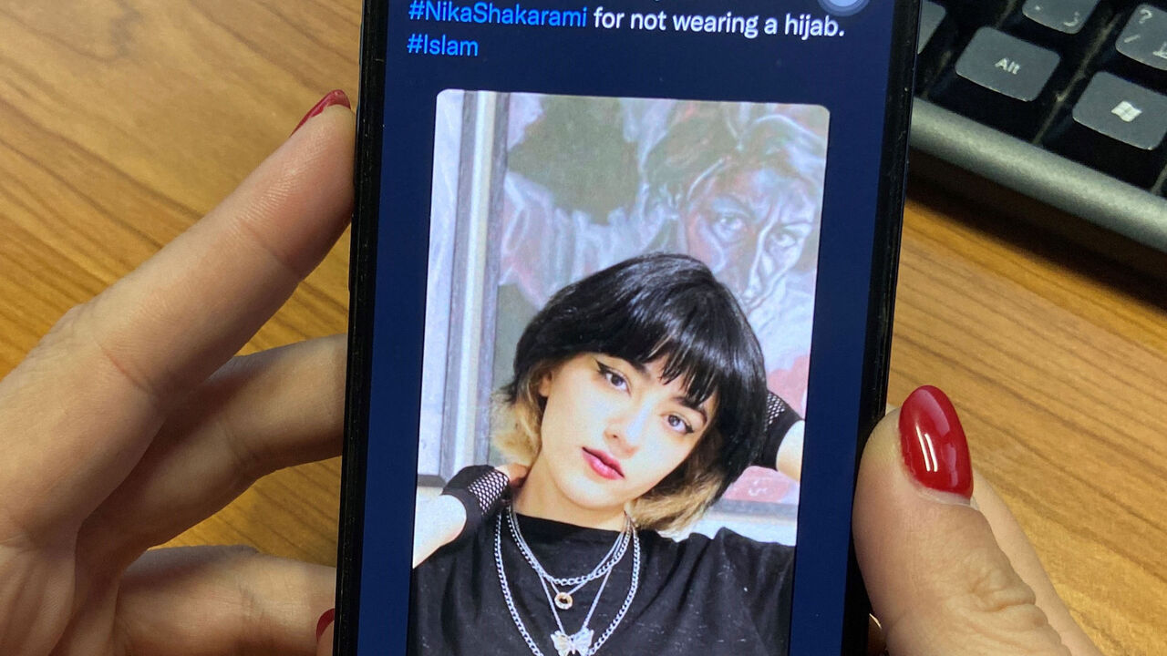 A woman looks at the profile picture of Iranian teenager Nika Shakrami who was reportedly killed recently during protests in Iran.