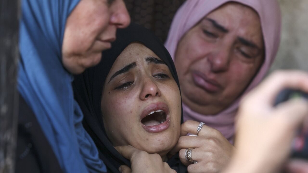 Relatives of Palestinian Basel Basbous, killed at dawn by Israeli forces, mourn as they gather at the Al-Jalazun refugee camp, near the Israeli settlement of Beit El in the occupied West Bank, on October 3, 2022