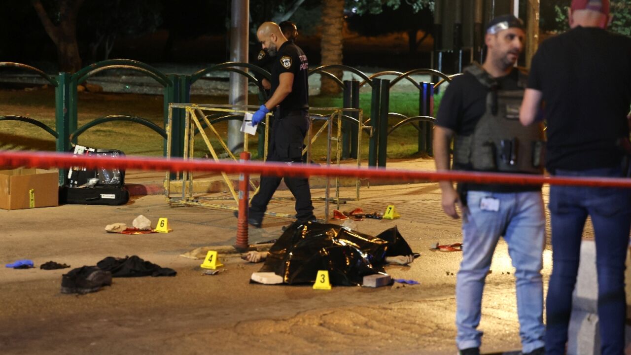 Israeli soldiers stand over a body following a reported attack at the entrance of the Israeli settlement of Maale Adumim in the occupied West Bank on Jerusalem's outskirts on October 19, 2022