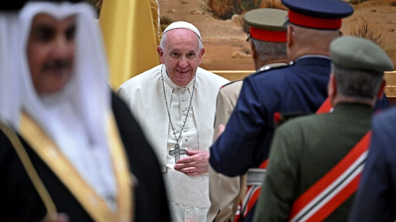 Pope Francis (C) greet dignitaries at the airport in Awali, south of the Bahraini capital Manama