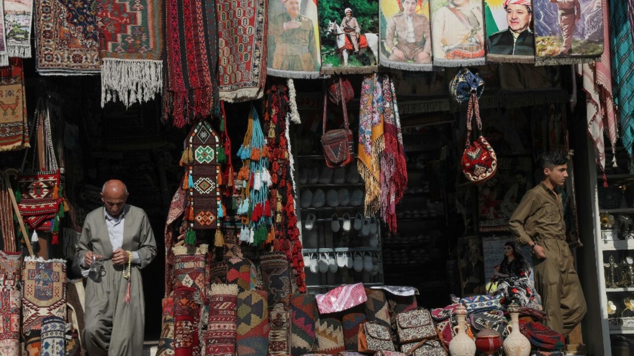 A Kurdish man sells rugs and artefacts at his shop near the citadel of Arbil, the capital of the autonomous Kurdish region of northern Iraq, on November 23, 2022