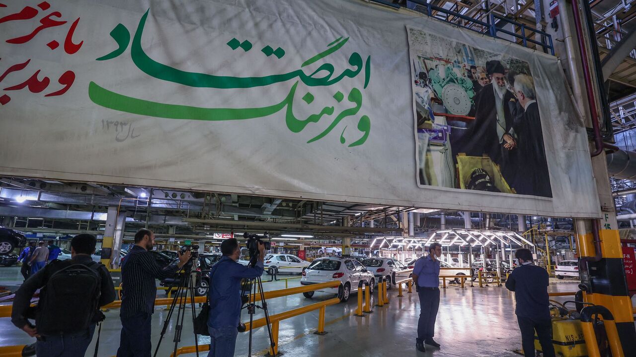 Journalists take images of Peugeot 207 and 206 car production lines at the Iran Khodro auto plant.