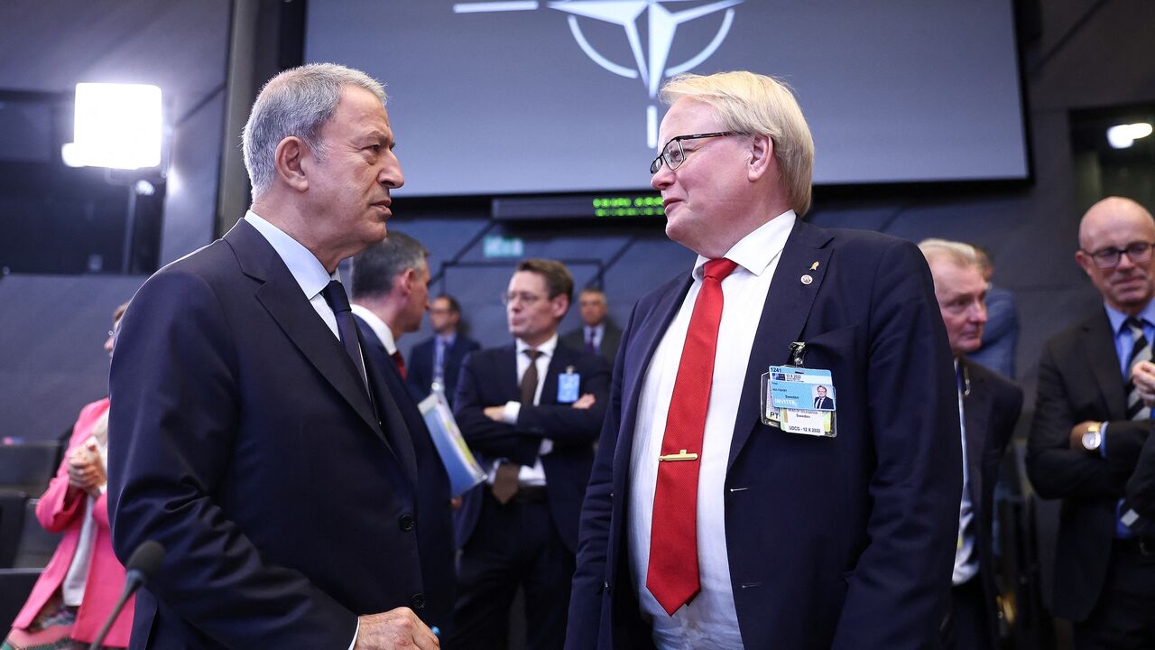 Turkish Defense Minister Hulusi Akar (L) speaks with Sweden's Defense Minister Peter Hultqvist ahead of the second day of a meeting of the alliance's Defense Ministers at the NATO headquarters in Brussels on Oct. 13, 2022.