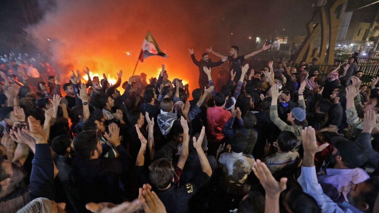 Demonstrators chant and burn tires as they gather in the Syrian opposition-held town of al-Bab.