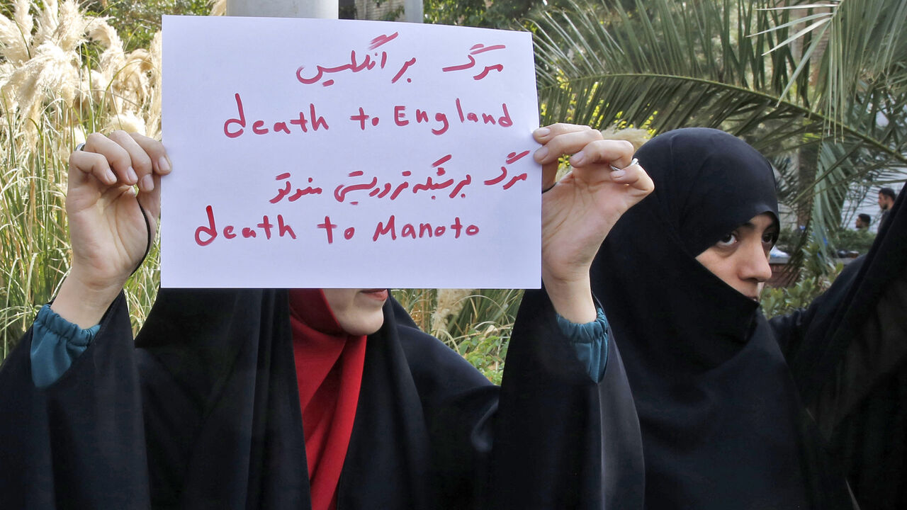A woman holds up a sign reading in Persian and English "Death to England, Death to Manoto.