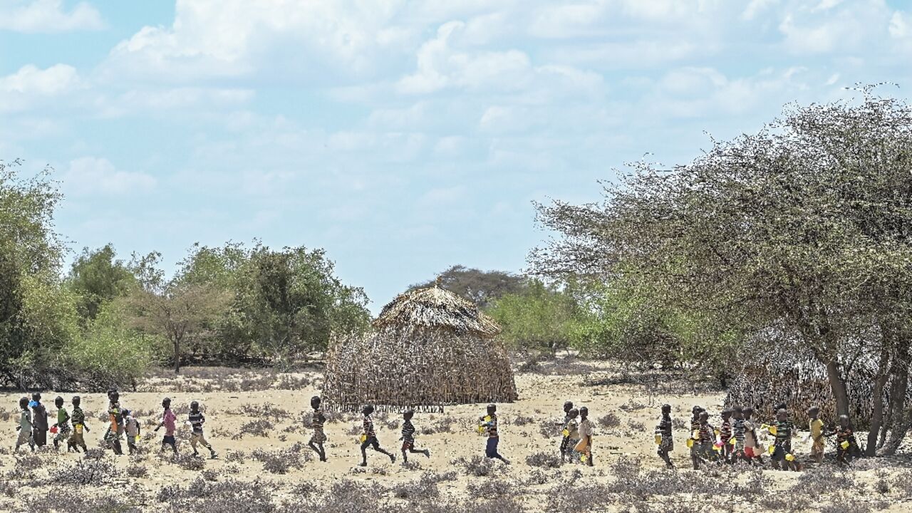 Children from Kenya's Turkana community walk in October to receive food aid; the wider Horn of Africa is facing its worst drought in more than four decades with over 20 million people impacted