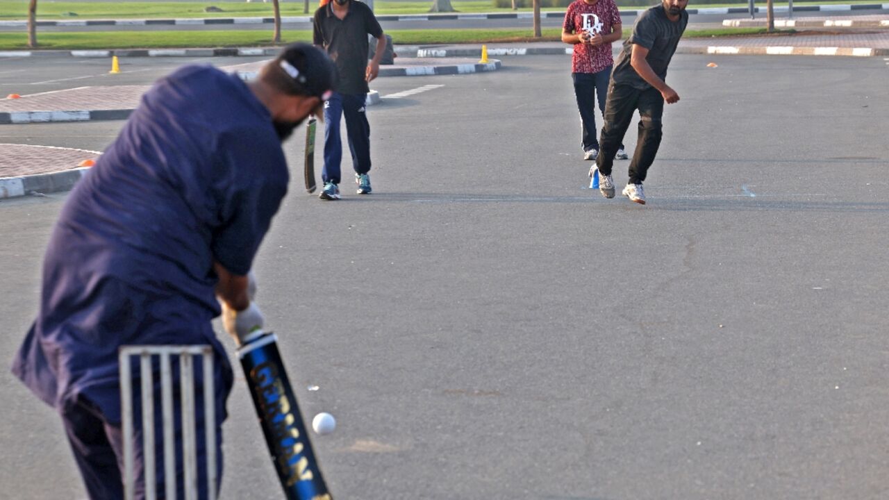 Expatriate workers play cricket in a parking lot in the Gulf emirate of Dubai Expatriate workers play cricket in a parking lot in the Gulf emirate of Dubai
