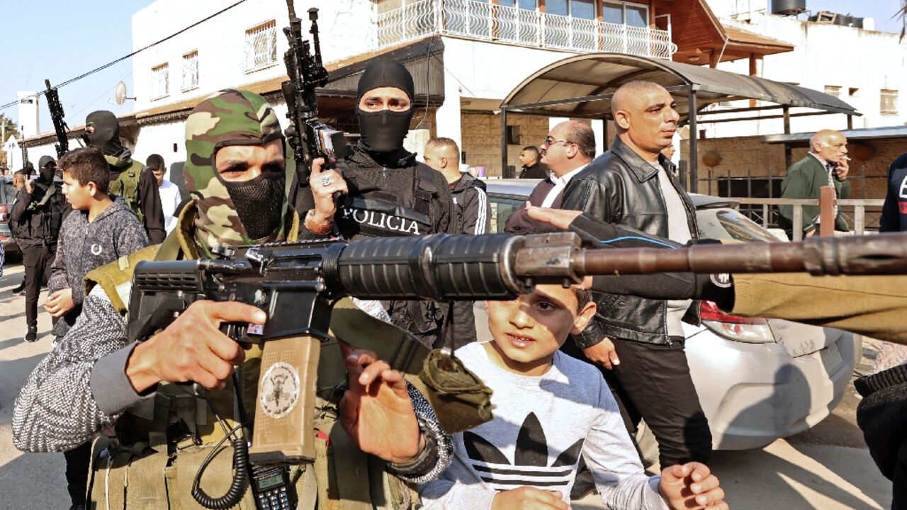 Palestinian gunmen take part in the funeral procession of three Palestinians killed by Israeli forces during a West Bank raid