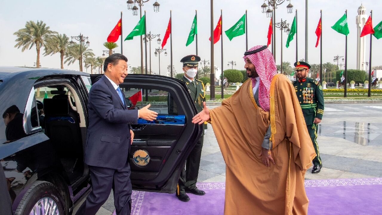 China's President Xi Jinping (L), greeted by Saudi Arabia's de facto ruler Crown Prince Mohammed bin Salman, is visiting during tensions between the kingdom and the United States