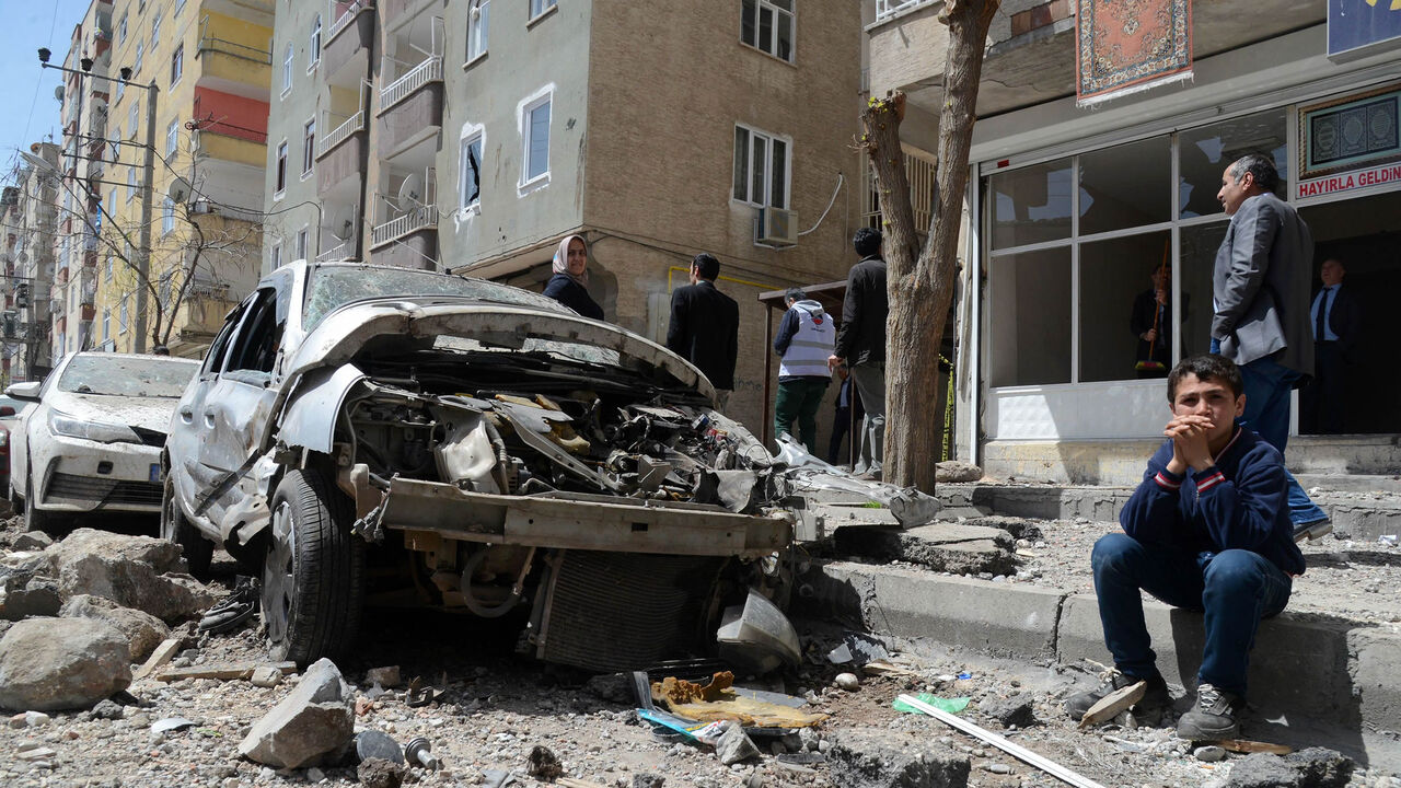 People gather near the site of an explosion that hit the police headquarters the day before in the Kurdish majority city of Diyarbakir, southeastern Turkey, April 12, 2017.