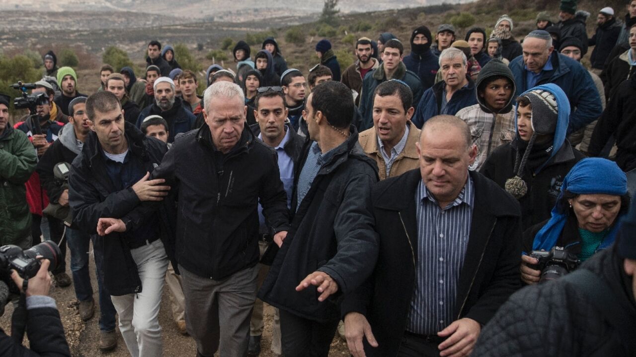 Yoav Gallant (C-L) pictured in 2016 when he was housing minister, is seen visiting the settlement outpost of Amona in the Israeli-occupied West Bank 