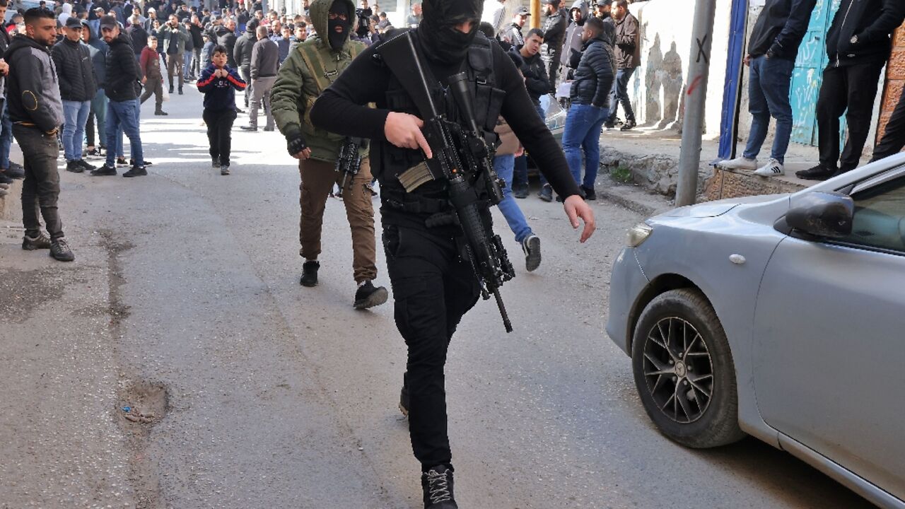 A Palestinian gunman attends the funeral of Samir Aslan, 41, at Qalandia refugee camp in the occupied West Bank, on January 12, 2023 A Palestinian gunman attends the funeral of Samir Aslan, 41, at Qalandia refugee camp in the occupied West Bank, on January 12, 2023