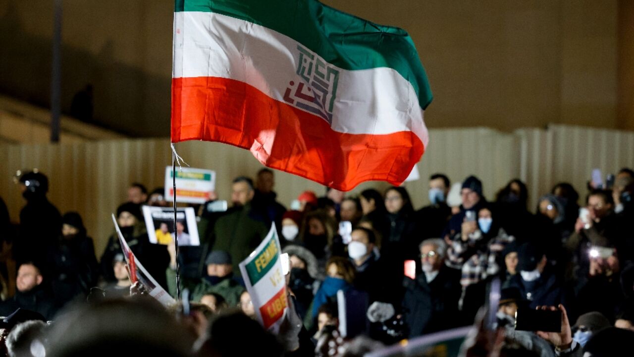 Protesters in Paris hold a flag with the slogan 'Woman. Life. Freedom' in solidarity with the protests