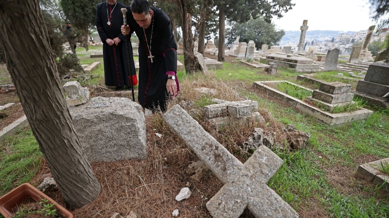 Hosam Naoum, archbishop and caretaker of the Protestant cemetery, inspects vandalised graves on Mount Zion outside Jerusalem's Old City Hosam Naoum, archbishop and caretaker of the Protestant cemetery, inspects vandalised graves on Mount Zion outside Jerusalem's Old City