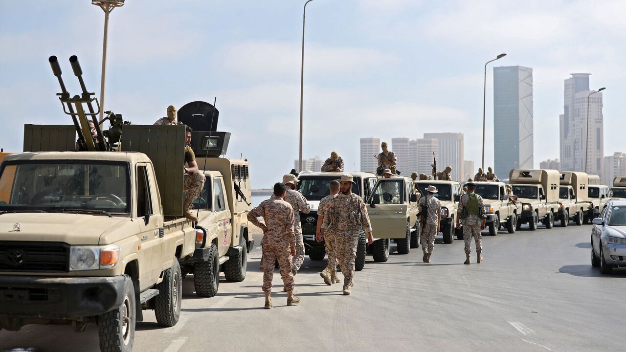 Vehicles of forces loyal to Libya's Tripoli-based Prime Minister Abdulhamid Dbeibah are parked along the waterfront (with the "That El Emad Towers" complex seen in the background) in the capital Tripoli on May 17, 2022 hours after forces of the rival Tobruk-based government withdrew following heavy fighting between opposing militias. (Photo by MAHMUD TURKIA/AFP via Getty Images)