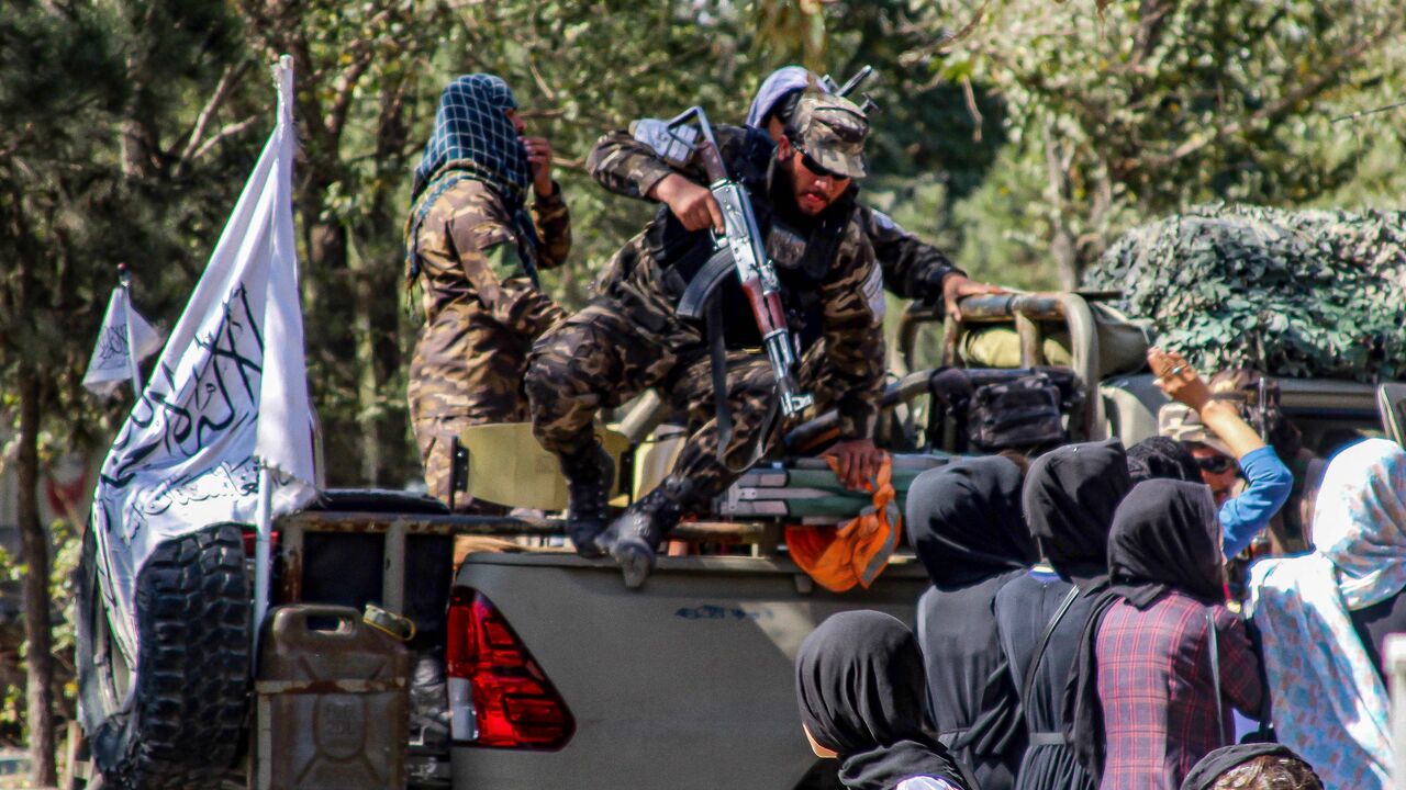 Members of the Taliban security forces arrive as Afghan women march during a demonstration they call Stop Hazara genocide a day after a suicide bomb attack at Dasht-e-Barchi learning centre, in Kabul on October 1, 2022. - (Photo by -/AFP via Getty Images)