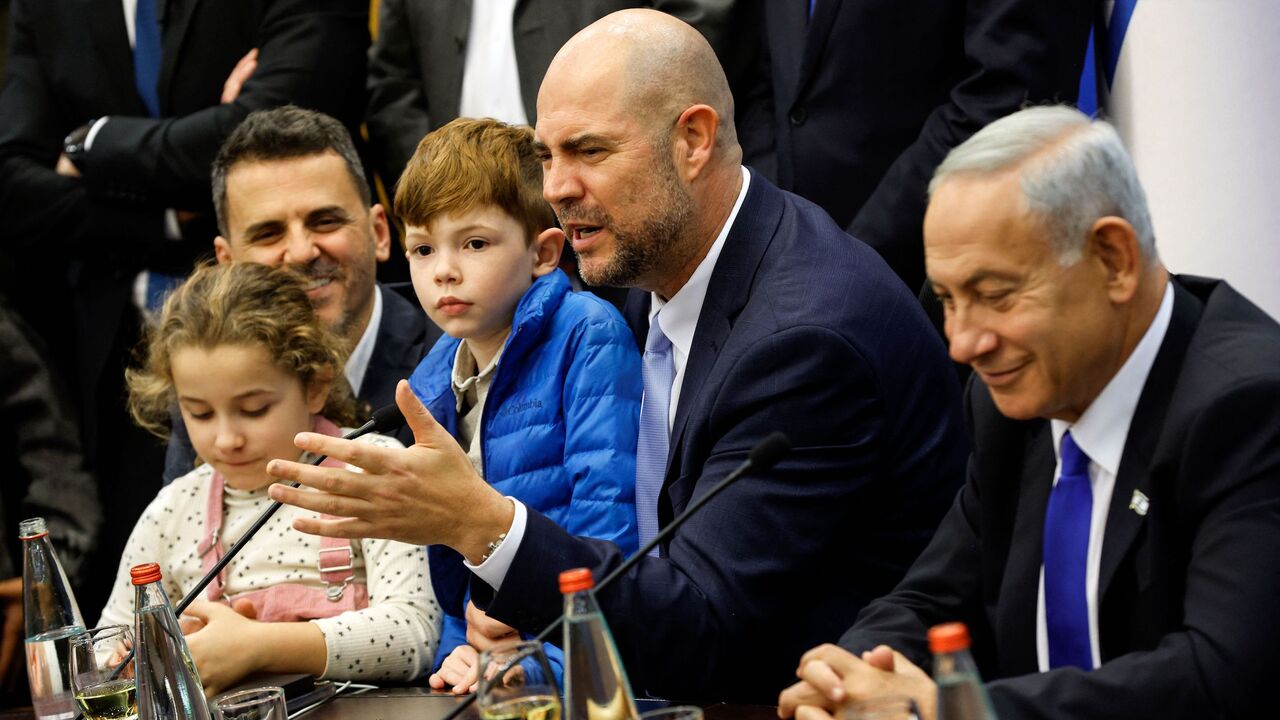 New Israeli Knesset (parliament) speaker Amir Ohana (C) speaks as his partner Alon (L), their children, and newly-sworn Prime Minister Benjamin Netanyahu (R) attend a toast in his honour at the Knesset in Jerusalem on Dec. 29, 2022.
