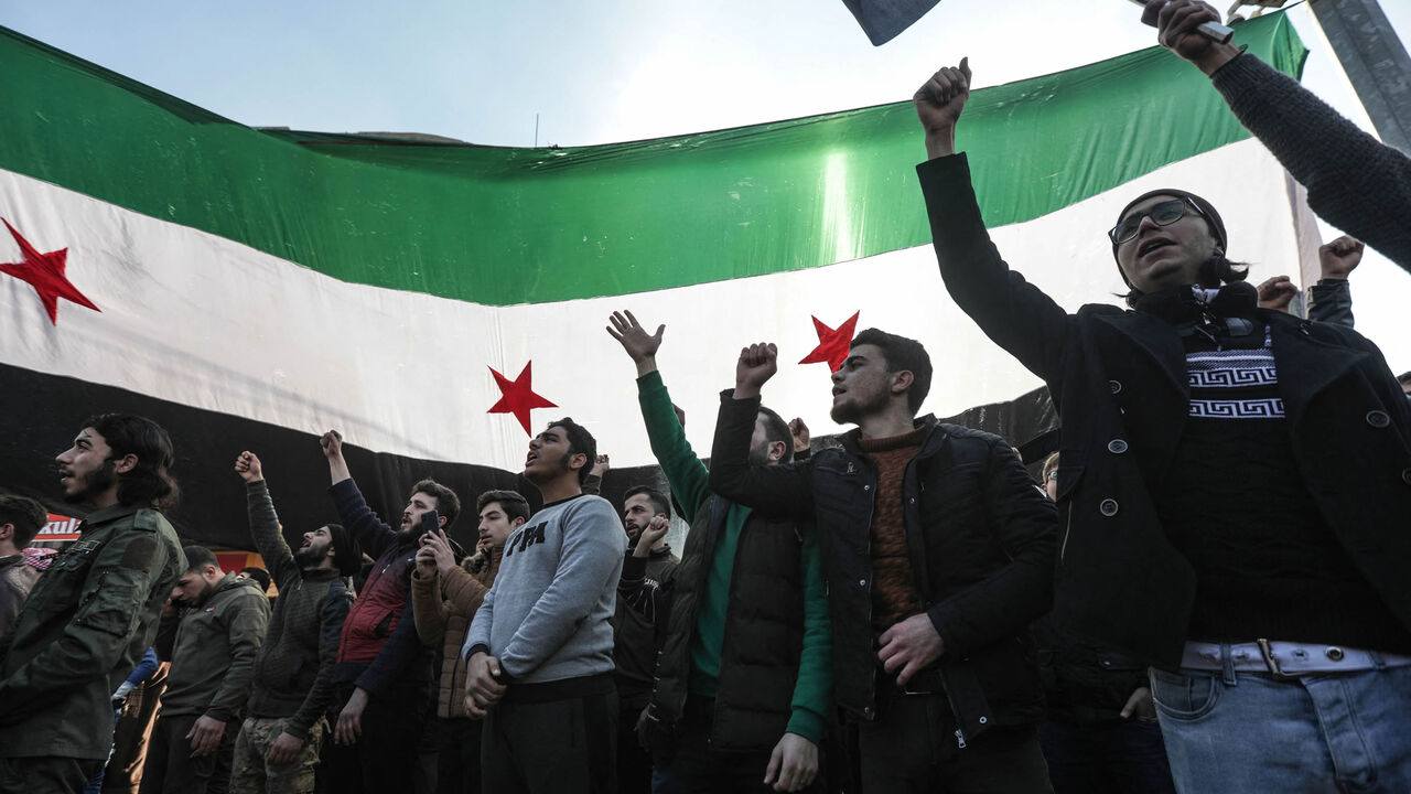 Demonstrators raise Syrian opposition flags and placards as they rally against a potential rapprochement between Ankara and the Syrian regime, al-Bab, on the border with Turkey, in Syria's northern Aleppo province, Dec. 30, 2022.