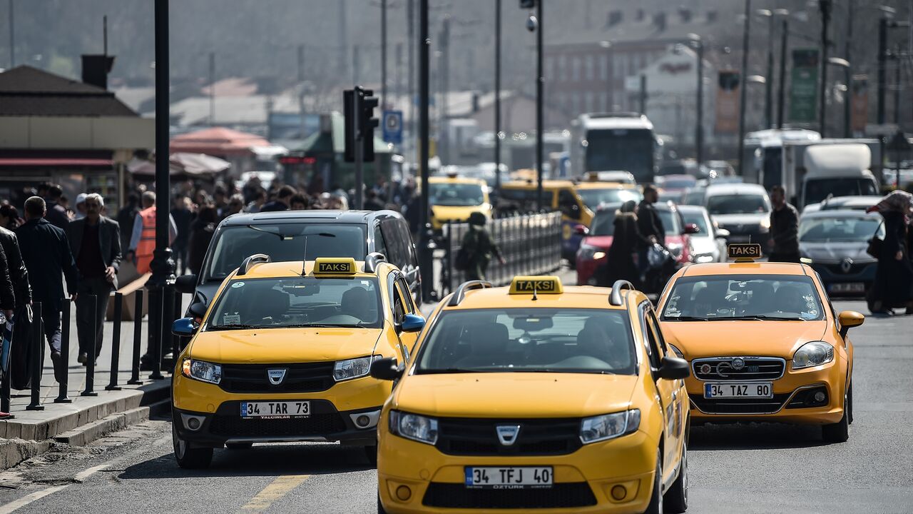 Official yellow taxis and van vehicles wait for their customers at the Eminonu district in Istanbul, on March 30, 2018. (Photo credit OZAN KOSE/AFP via Getty Images)